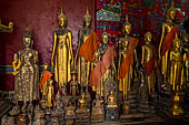 Wat Xieng Thong temple in Luang Prabang, Laos. standing Buddha statues in the  calling for rain  mudra with both arms down at sides and palms against thighs. Royal Funerary carriage hall. 